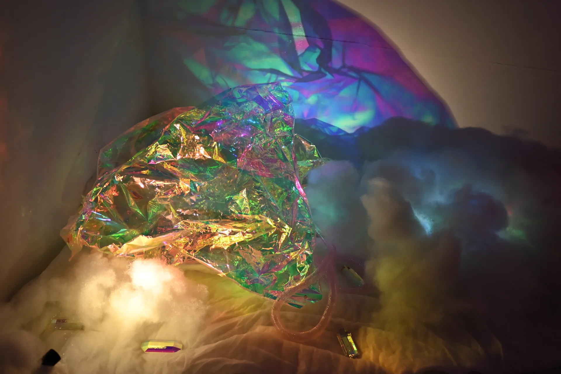 Iridescent folds scatter green and gold light across soft white fibers
